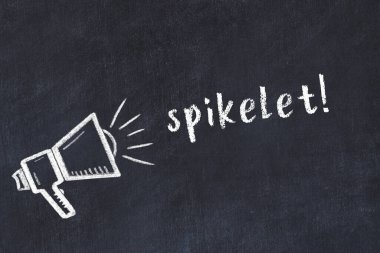 Hoparlörün tebeşir çizimi ve siyah masanın üzerine el yazısıyla yazılmış yazması.