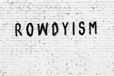 Beyaz tuğlalı duvar, siyah boyayla yazılmış kabadayılık.