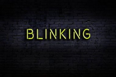 Üzerinde yazı olan neon levhası tuğla duvara çarpıyor. Gece görünümü