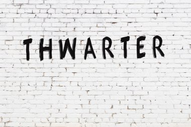 Beyaz tuğla duvara siyah boya ile yazılmış bir yazıt engelleyici..