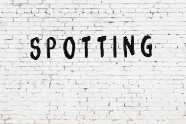 Üzerinde yazı olan beyaz tuğla duvar. Siyah boyayla yazılmış.