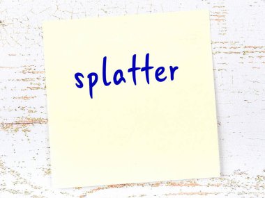 Tahta duvardaki sarı yapışkan notta el yazısı sıçrama izi var.