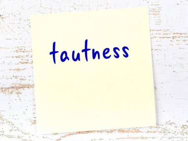 Ahşap duvardaki sarı yapışkan notta elle yazılmış yazılar var.