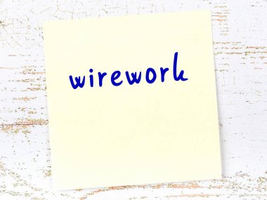 Tahta duvardaki sarı yapışkan notta el yazısıyla yazılmış kablolar var.