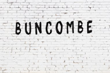 Üzerinde siyah boya olan beyaz tuğlalı bir duvar.