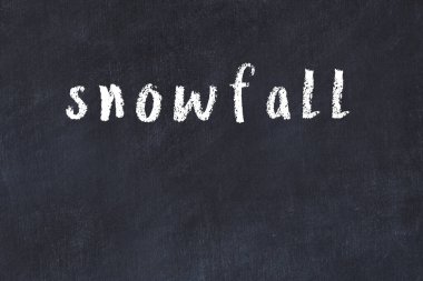 Tebeşir el yazısıyla yazılmış kar yağışlı siyah masanın üstüne