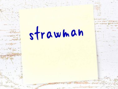 Strawman 'ı hatırlatma kavramı. Tahta duvarda üzerinde yazı olan sarı yapışkan kağıt.