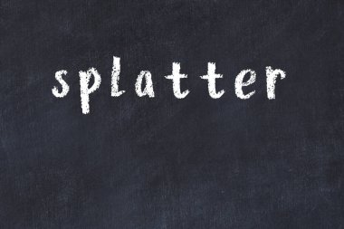 Tebeşir el yazısıyla yazılmış yazı siyah masaya sıçramış.