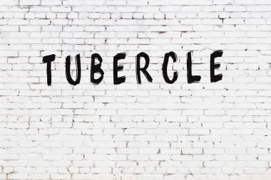 Siyah boyalı el yazısıyla yazması tüberküloz olan beyaz tuğla bir duvar.