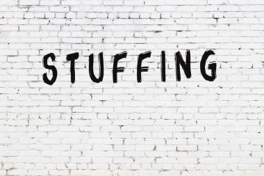 Beyaz tuğla duvara siyah boya ile yazılmış yazılar..