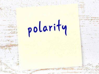 Tahta duvardaki sarı yapışkan notta el yazısıyla yazılmış kutuplaşma var.