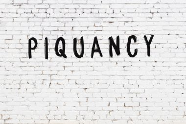 Üzerinde siyah boya bulunan beyaz tuğlalı bir duvar.