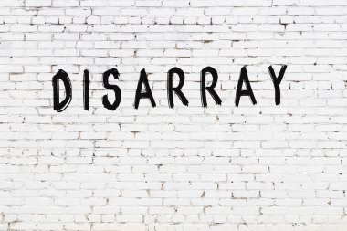 Üzerinde siyah boya bulunan beyaz tuğla bir duvar.