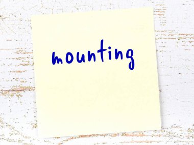 Montaj hakkında hatırlatma kavramı. Tahta duvarda üzerinde yazı olan sarı yapışkan kağıt.