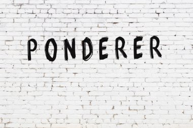 Beyaz tuğla duvara siyah boya ile yazılmış bir yazıt düşünürü..