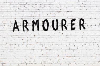 Üzerinde siyah boya bulunan beyaz tuğla bir duvar.