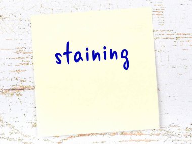 Lekelemeyi hatırlatma kavramı. Tahta duvarda üzerinde yazı olan sarı yapışkan kağıt.