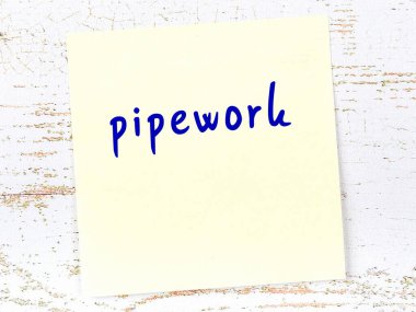 Boru işleriyle ilgili hatırlatma kavramı. Tahta duvarda üzerinde yazı olan sarı yapışkan kağıt.