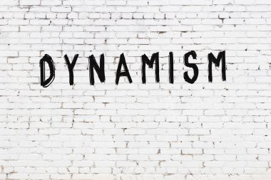 Üzerinde siyah boya bulunan beyaz tuğladan bir duvar.