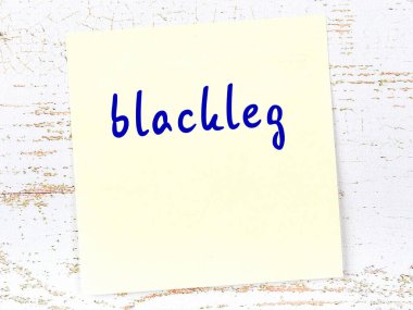 Tahta duvarda sarı yapışkan bir not ve el yazısıyla yazılmış bir karatahta.