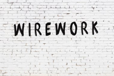 Siyah boyalı el yazısıyla yazılmış beyaz tuğlalı bir duvar.