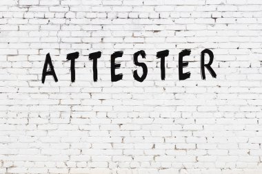 Üzerinde siyah boya bulunan beyaz tuğladan bir duvar.