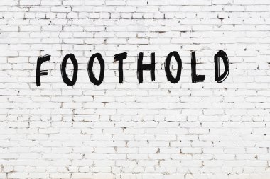 Üzerinde siyah boya bulunan beyaz tuğla bir duvar.