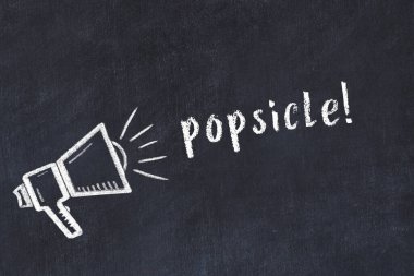 Hoparlörün tebeşir çizimi ve siyah masanın üzerine el yazısıyla yazılmış buzlu şeker.