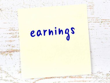 Tahta duvardaki sarı yapışkan notta el yazısıyla yazılmış kazançlar var.