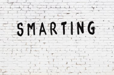 Üzerinde yazı olan beyaz tuğla duvar. El yazısıyla siyah boya.