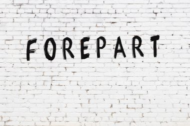 Üzerinde yazı olan beyaz tuğla duvar. Önden siyah boyayla yazılmış.