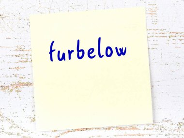 Ahşap duvardaki sarı yapışkan notun altında el yazısıyla yazılmış bir yazı var.