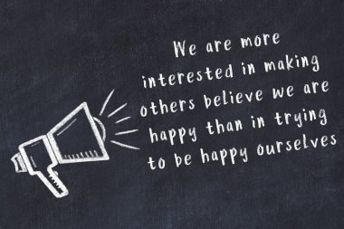 Bir hoparlörün tebeşir çizimi ve siyah karatahtaya el yazısıyla yazılmış alıntılar