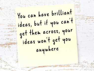 Sarı yapışkan not, ahşap duvarda el yazısıyla yazılmış zekice bir alıntıyla.