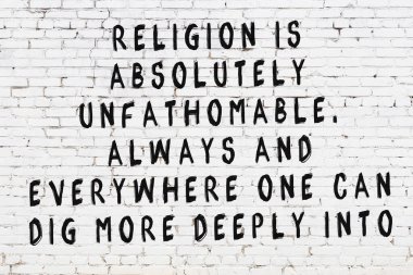 Üzerinde mantıklı alıntıların yazılı olduğu siyah boyanmış beyaz tuğla duvar.