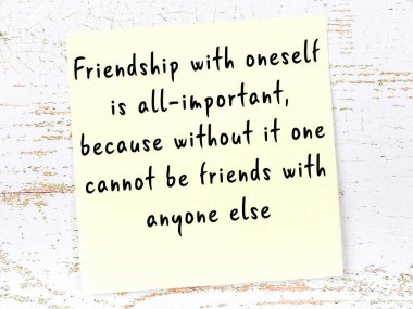 Sarı yapışkan not, ahşap duvarda el yazısıyla yazılmış zekice bir alıntıyla.