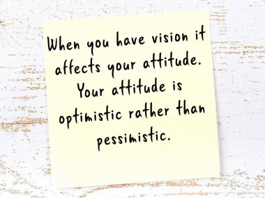 Tahta duvarda asılı sarı yapışkan nota elle yazılmış bilgece bir alıntı.