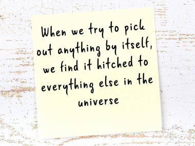 Tahta duvarda el yazısı motivasyon alıntısı olan sarı yapışkan not