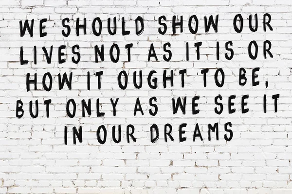 Beyaz tuğla duvar ve bilgece alıntıların yazılı olduğu siyah yazı.