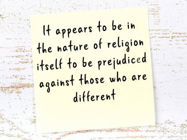 Sarı yapışkan not, ahşap duvarda el yazısıyla yazılmış zekice bir alıntıyla.