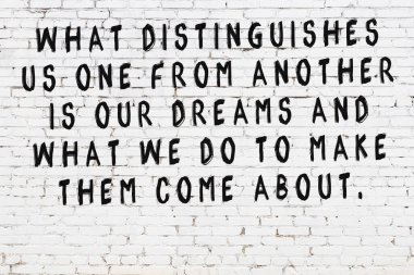 Beyaz tuğla duvar ve bilgece alıntıların yazılı olduğu siyah yazı.