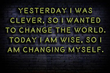 Tuğla duvardaki ışıklı neon tabela olarak bilgece alıntı