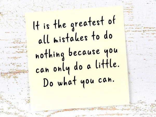 Tahta duvarda el yazısı motivasyon alıntısı olan sarı yapışkan not