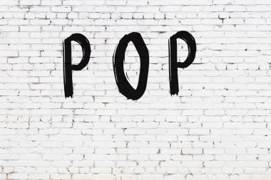 Beyaz tuğla duvara siyah boya ile yazılmış bir yazı..