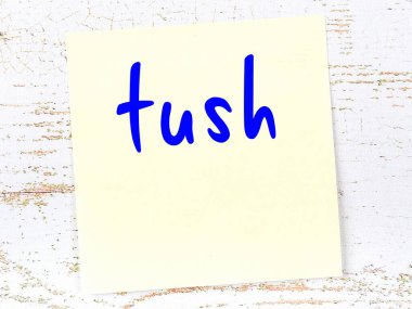 Tahta duvarda, el yazısıyla yazılmış poposu olan sarı yapışkan bir not.