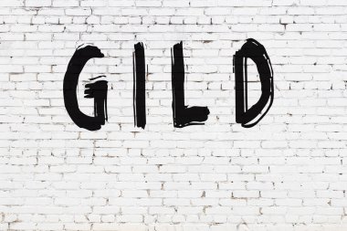 Siyah boyalı el yazısıyla altın işlemeli beyaz tuğla duvar.