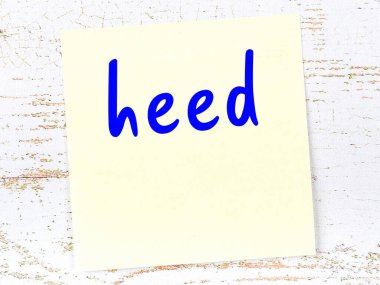 Dikkat hakkında hatırlatma kavramı. Tahta duvarda üzerinde yazı olan sarı yapışkan kağıt.