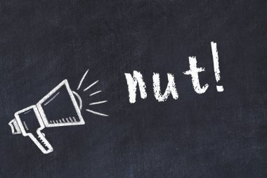 Hoparlörün tebeşir çizimi ve siyah masanın üzerine el yazısıyla yazılmış fındık.