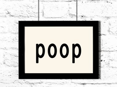 Siyah ahşap çerçeve ve beyaz tuğla duvarda yazı kakası var. 