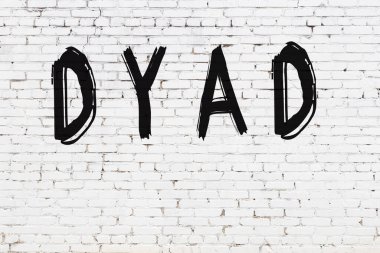 Üzerinde yazı olan beyaz tuğla duvar. Siyah boyayla el yazısı.